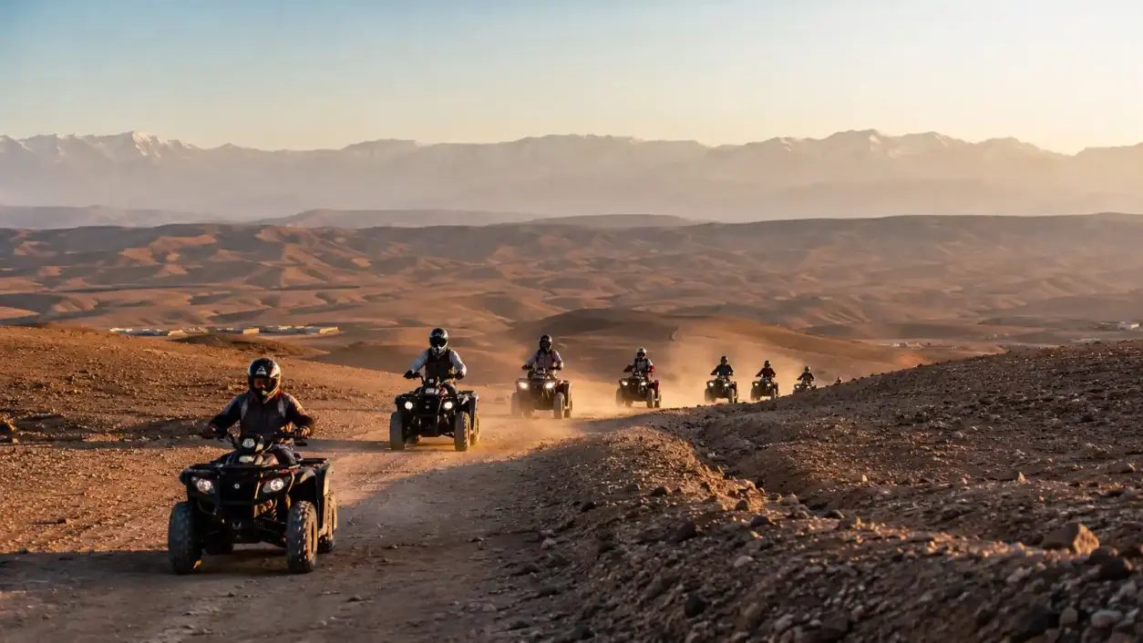 Groupe de quads roulant dans le désert d'Agafay avec les montagnes de l'Atlas en arrière-plan